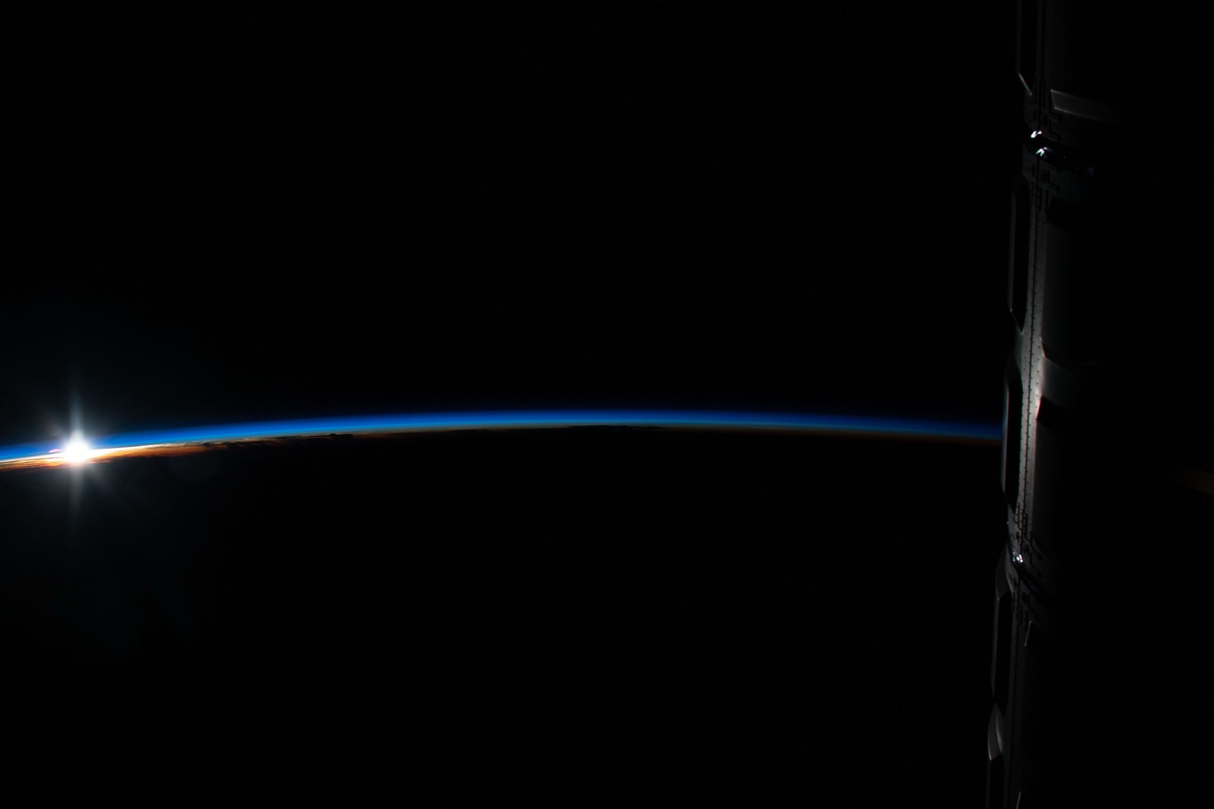 Sunrise over the curve of the Earth, photographed from the International Space Station.